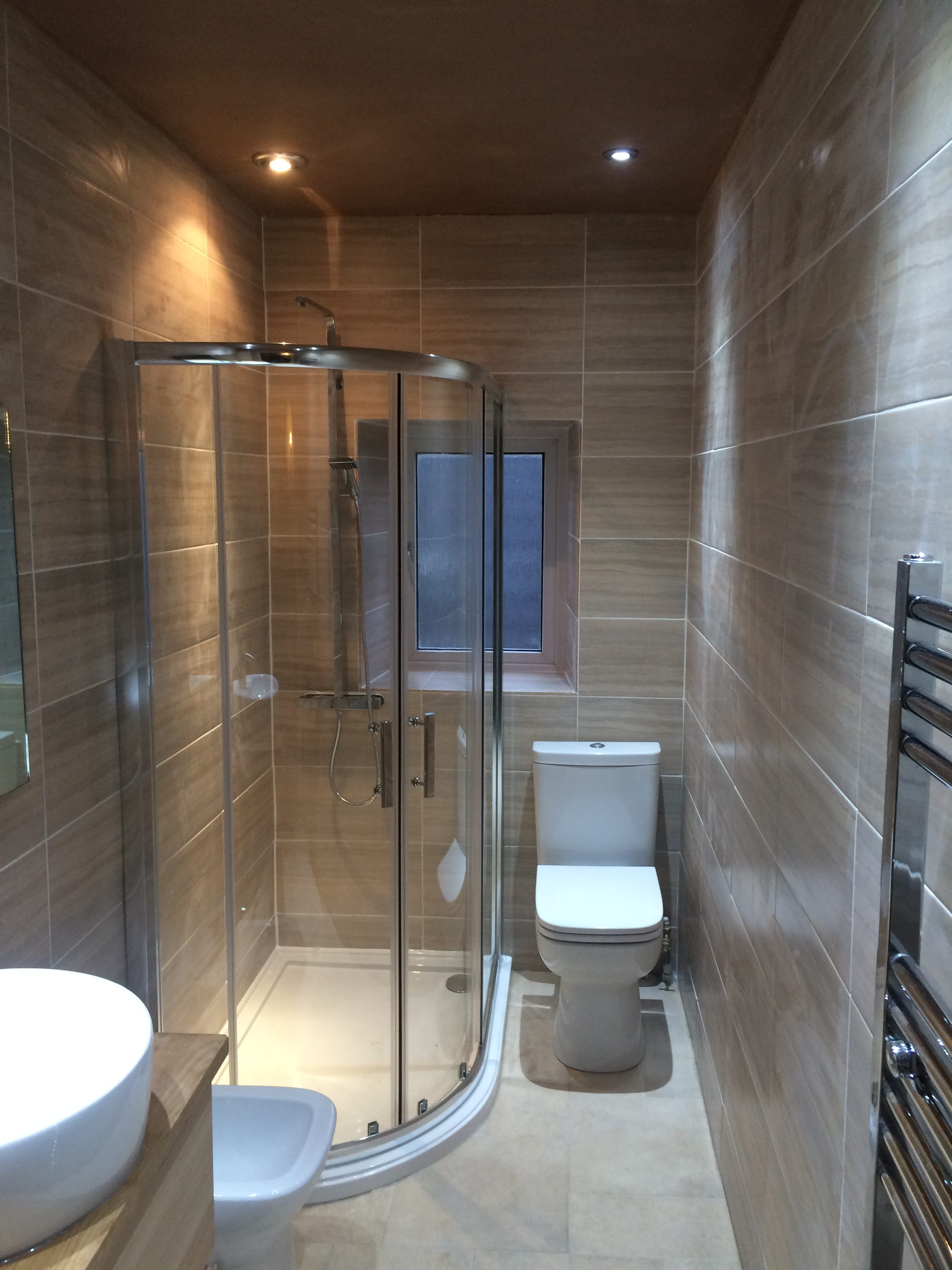 Shower and toilet in modern long bathroom
